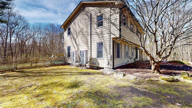 view of side of property with fence and a lawn