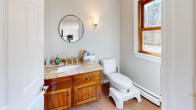 half bath with toilet, a baseboard radiator, vanity, and tile patterned floors
