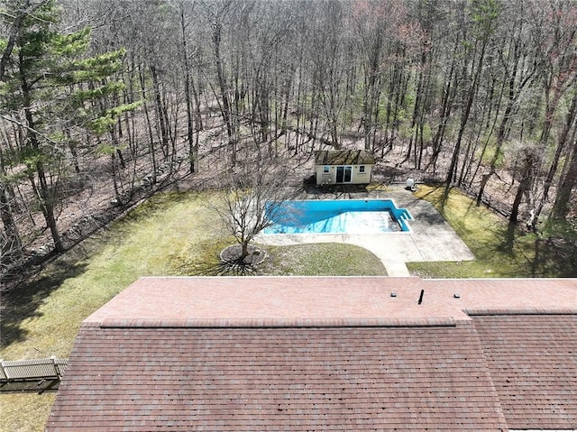 view of pool featuring a yard, a patio area, fence, an outdoor structure, and a fenced in pool