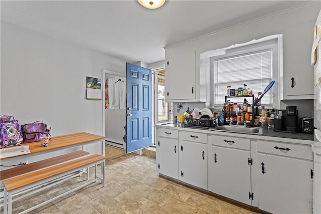 345 Post Rd, Warwick, RI 02888 - kitchen with a healthy amount of sunlight, a baseboard heating unit, white cabinetry, and stone finish flooring
