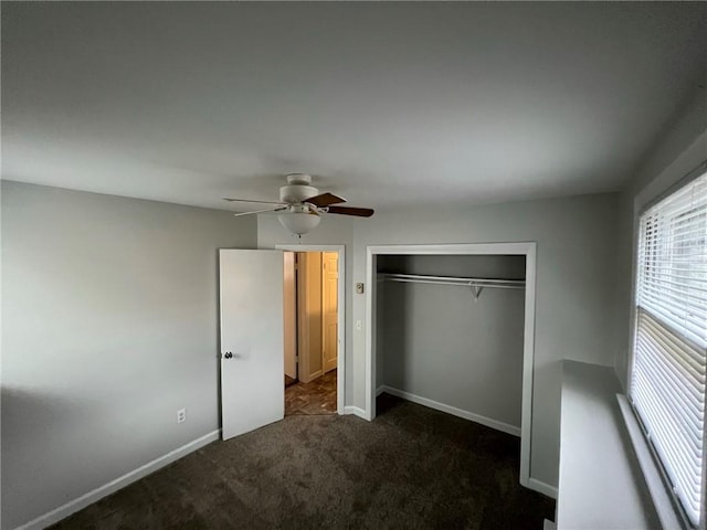 345 Post Rd, Warwick, RI 02888 - unfurnished bedroom featuring dark carpet, a closet, baseboards, and a ceiling fan
