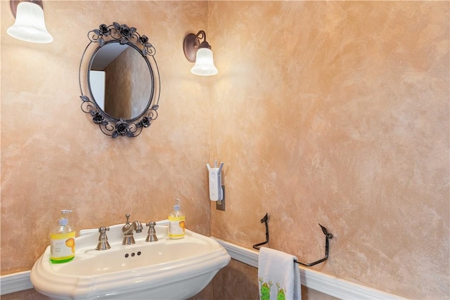 bathroom featuring baseboards and a sink