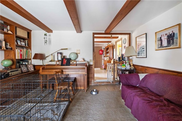 carpeted living room featuring beam ceiling