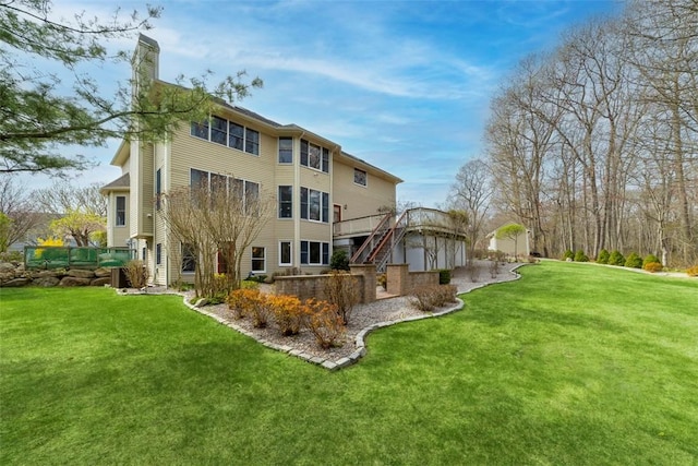 174 Windmill Dr, South Kingstown, RI 02879 - back of house with stairs, a wooden deck, a yard, and a chimney