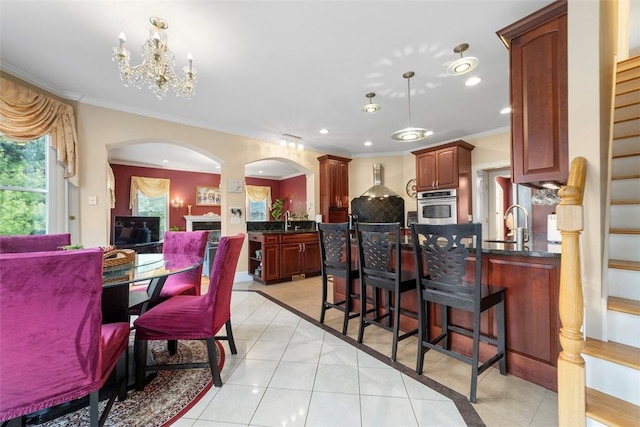 174 Windmill Dr, South Kingstown, RI 02879 - dining room featuring crown molding, light tile patterned flooring, an inviting chandelier, arched walkways, and stairway