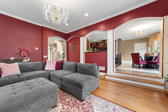 174 Windmill Dr, South Kingstown, RI 02879 - living room with crown molding, arched walkways, a chandelier, recessed lighting, and wood finished floors