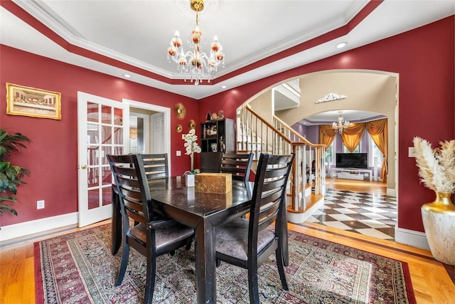 174 Windmill Dr, South Kingstown, RI 02879 - dining area with an inviting chandelier, arched walkways, a tray ceiling, ornamental molding, and stairway
