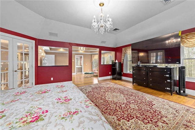 174 Windmill Dr, South Kingstown, RI 02879 - bedroom featuring french doors, wood finished floors, visible vents, and an inviting chandelier