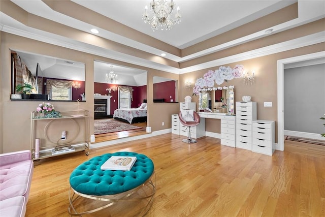 174 Windmill Dr, South Kingstown, RI 02879 - bedroom with baseboards, an inviting chandelier, a glass covered fireplace, and wood finished floors