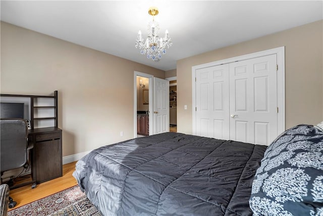 174 Windmill Dr, South Kingstown, RI 02879 - bedroom with baseboards, a closet, light wood-type flooring, and a notable chandelier
