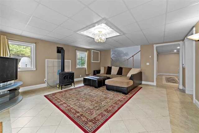 174 Windmill Dr, South Kingstown, RI 02879 - living room with baseboards, a drop ceiling, light tile patterned floors, and a wood stove