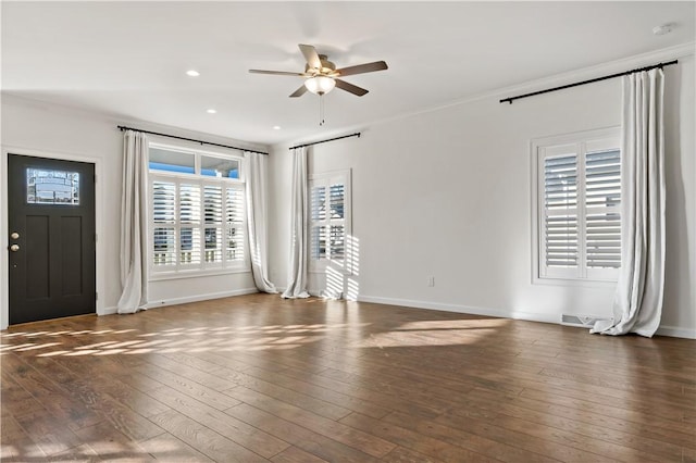unfurnished living room with crown molding, ceiling fan, hardwood / wood-style flooring, and baseboards