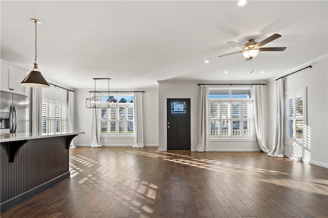 unfurnished living room featuring dark wood-style floors, baseboards, and a ceiling fan