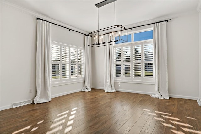 unfurnished dining area with a wealth of natural light, a notable chandelier, visible vents, and wood finished floors