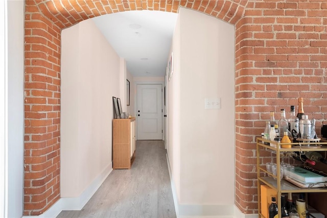 corridor with baseboards and light wood-style floors