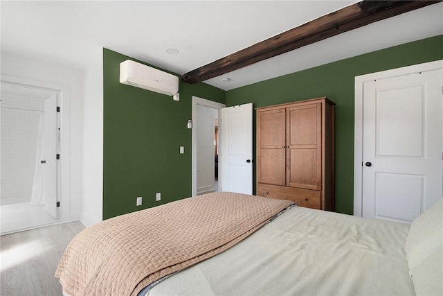 bedroom featuring beamed ceiling, wood finished floors, and a wall mounted air conditioner