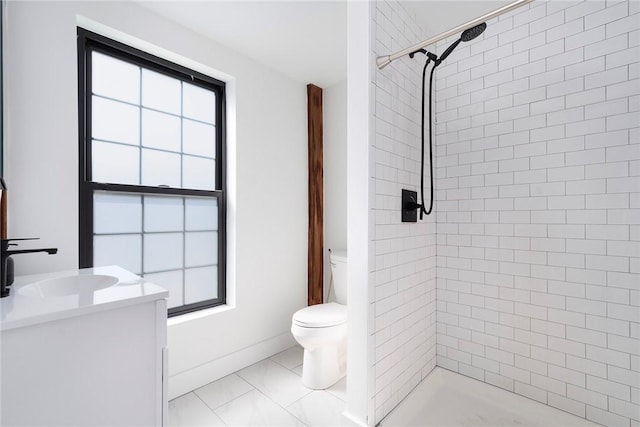 full bathroom with vanity, a tile shower, and toilet