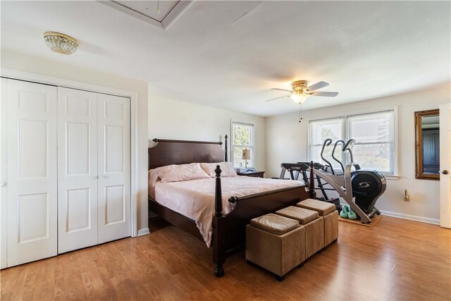 bedroom featuring a closet, a ceiling fan, light wood finished floors, and baseboards
