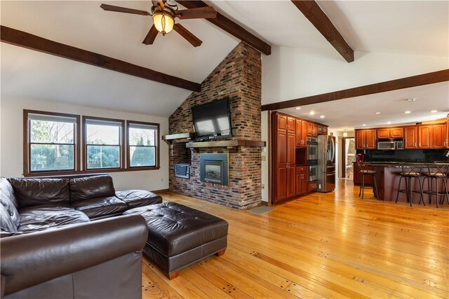 living room featuring recessed lighting, beamed ceiling, light wood-style floors, a fireplace, and a ceiling fan