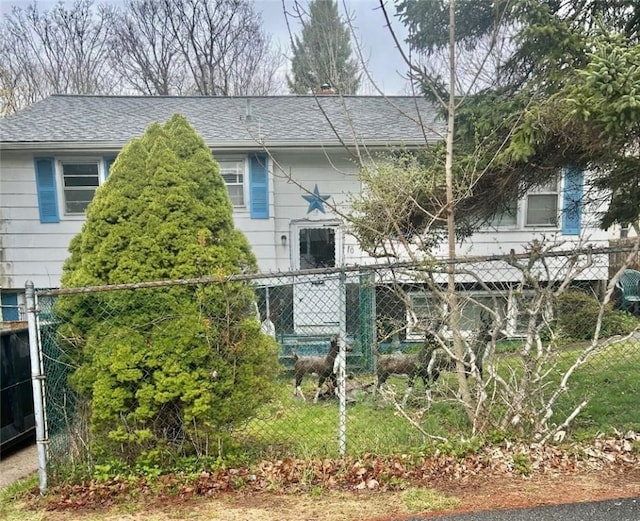 back of property featuring roof with shingles and fence