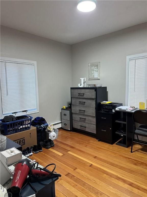 home office with light wood-style flooring and a baseboard radiator