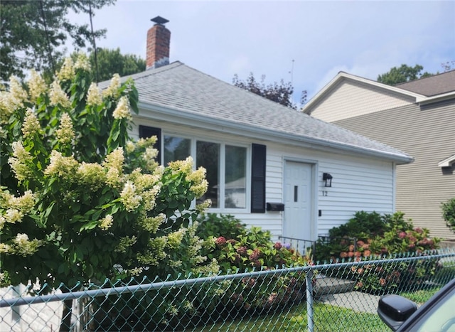 view of front of house featuring fence and a shingled roof