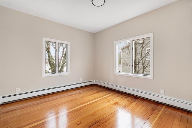unfurnished room with a baseboard heating unit, a baseboard radiator, and hardwood / wood-style flooring