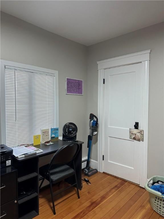 home office with a baseboard radiator and light wood finished floors