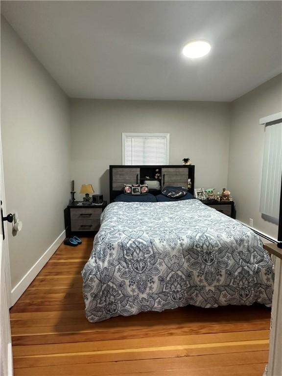 bedroom with baseboards and wood finished floors