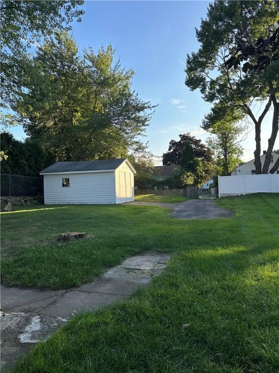view of yard with a storage shed, fence, and an outdoor structure