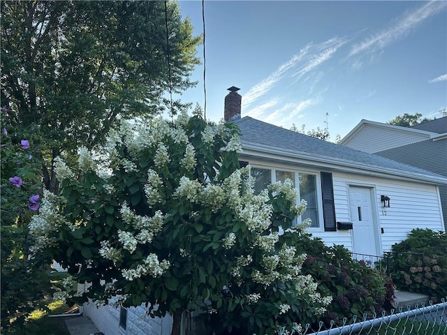 view of front of home featuring roof with shingles and a chimney