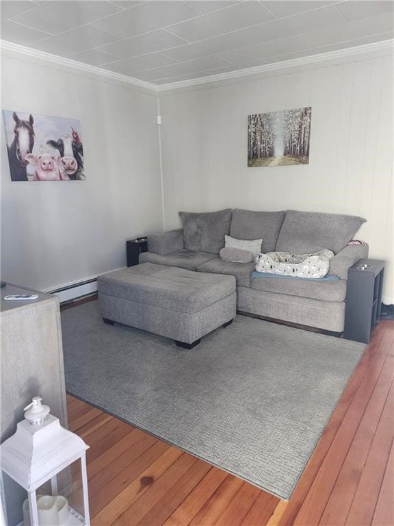 living area featuring wood-type flooring, baseboard heating, and ornamental molding
