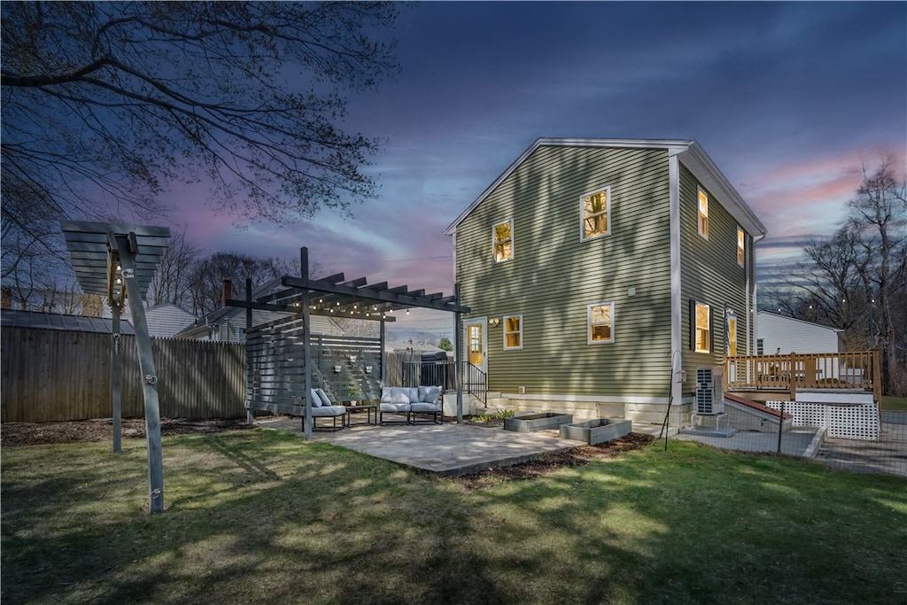 rear view of property with a pergola, a lawn, a patio, fence, and a deck