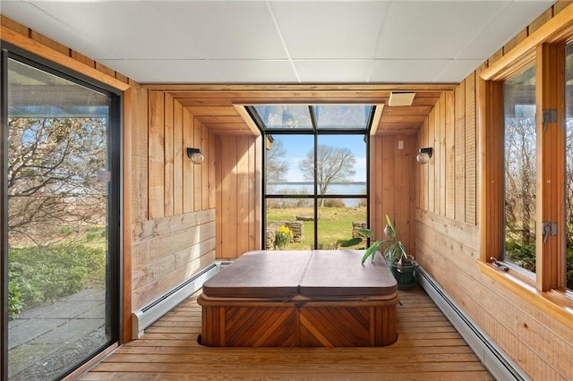 sunroom / solarium featuring plenty of natural light, a baseboard radiator, and a hot tub
