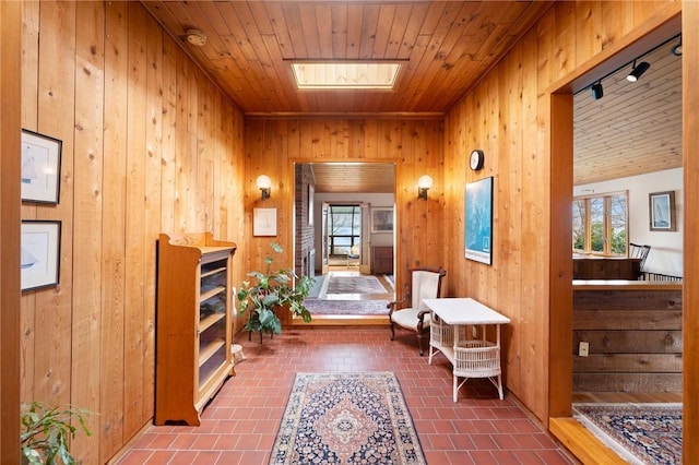sitting room with wood ceiling, wooden walls, and a wealth of natural light