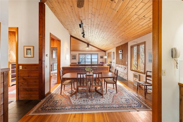 dining room featuring wood-type flooring, vaulted ceiling, wooden ceiling, and radiator