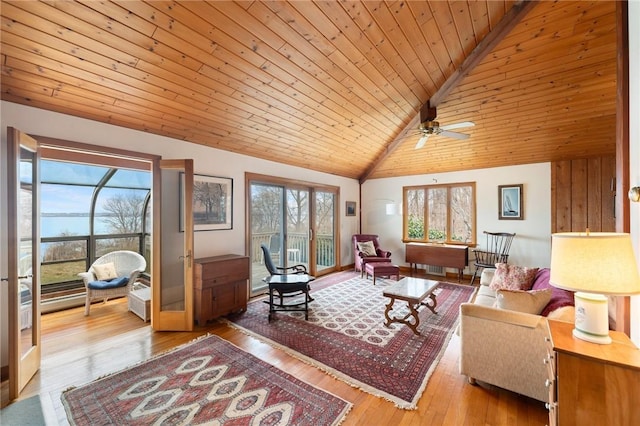 living area featuring lofted ceiling, wood ceiling, a ceiling fan, and a healthy amount of sunlight