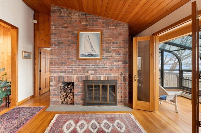unfurnished living room featuring a fireplace, wood ceiling, wood finished floors, and lofted ceiling