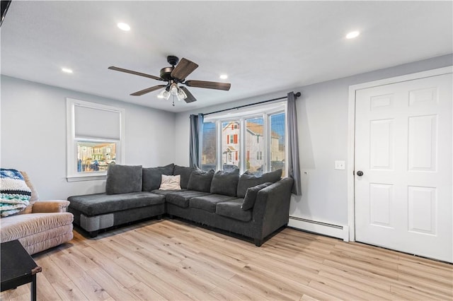 living room featuring light wood-style flooring, a baseboard heating unit, and recessed lighting