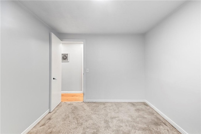 spare room featuring carpet and baseboards
