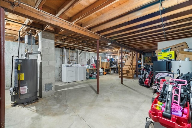 unfinished below grade area with stairs, water heater, and separate washer and dryer