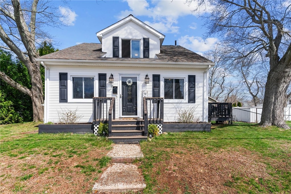 bungalow-style house featuring a front lawn, roof with shingles, and fence