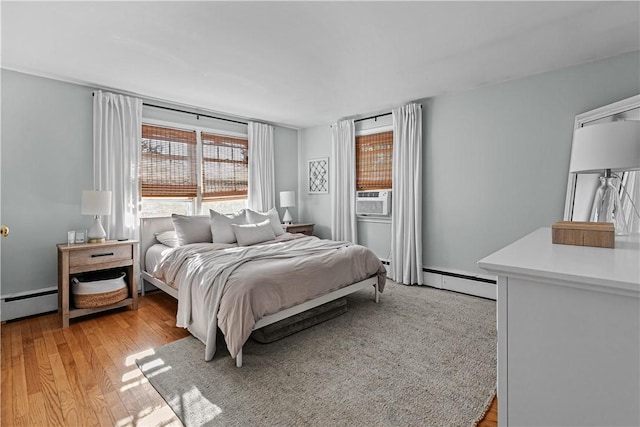 bedroom with light wood-style flooring, a baseboard radiator, and cooling unit