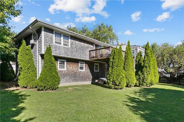 rear view of property featuring a yard, fence, and a deck