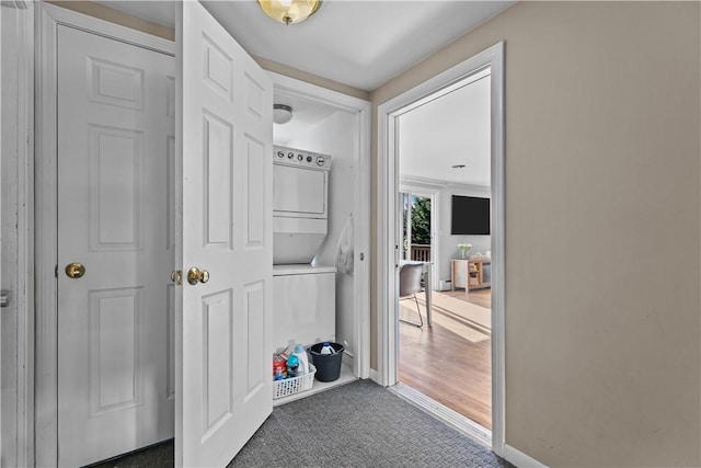 mudroom featuring carpet and stacked washer and clothes dryer