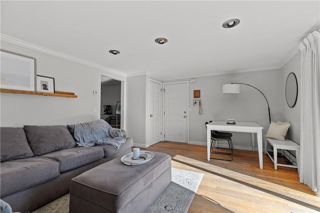 living area with crown molding, wood finished floors, and baseboards