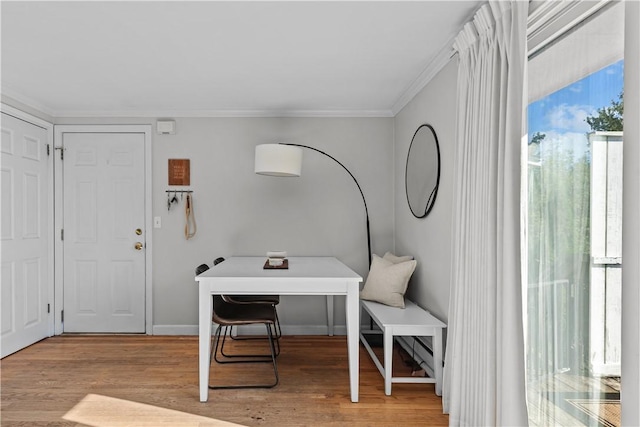 office space with ornamental molding, light wood-style flooring, and baseboards