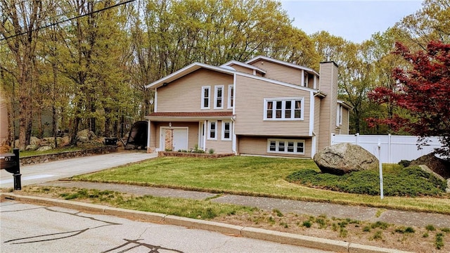 67 Highwood Dr, Coventry, RI 02816 - view of front of house featuring a chimney, fence, a garage, concrete driveway, and a front yard
