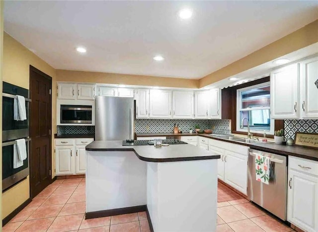 67 Highwood Dr, Coventry, RI 02816 - kitchen featuring a sink, tasteful backsplash, white cabinetry, dark countertops, and appliances with stainless steel finishes