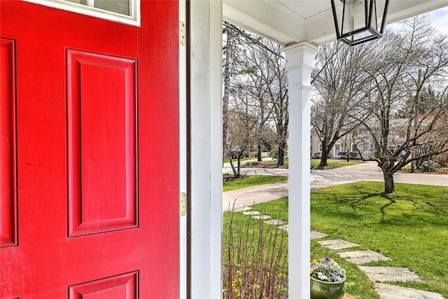 entrance to property featuring a yard and a porch